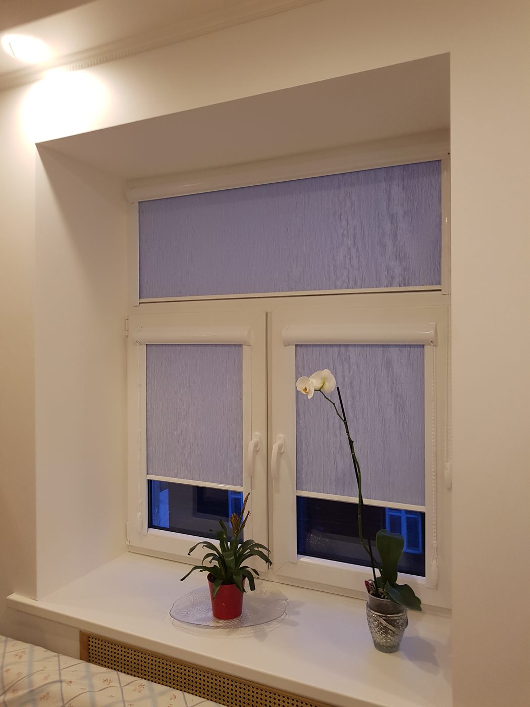Ceriņkrāsas kasešu žalūzijas nišas logā ar augšējo vērtni Ceriņkrāsas kasešu žalūzijas nišas logā ar augšējo vērtni