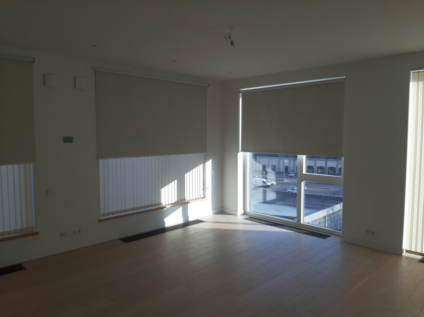 Bēšas rullo žalūzijas uz dzīvokļa panorāmas durvīm un logiem Bēšas rullo žalūzijas uz dzīvokļa panorāmas durvīm un logiem